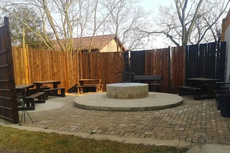 The braai and seating area, enclosed by a timber fence
