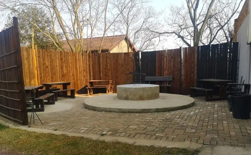 The boma area, with a central fire pit and timber benches under a thatched screen