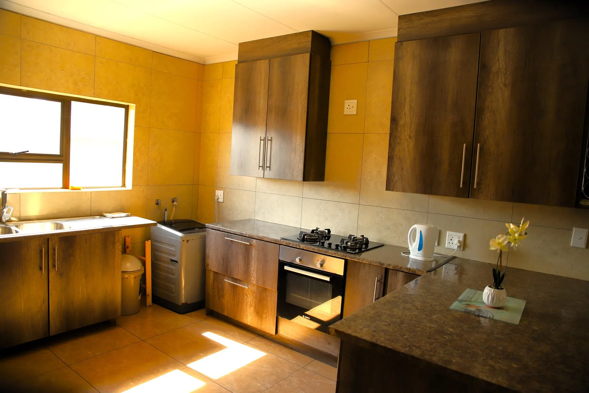 The fitted kitchen in the Bouleigh apartment, with gas hob, oven and washing machine