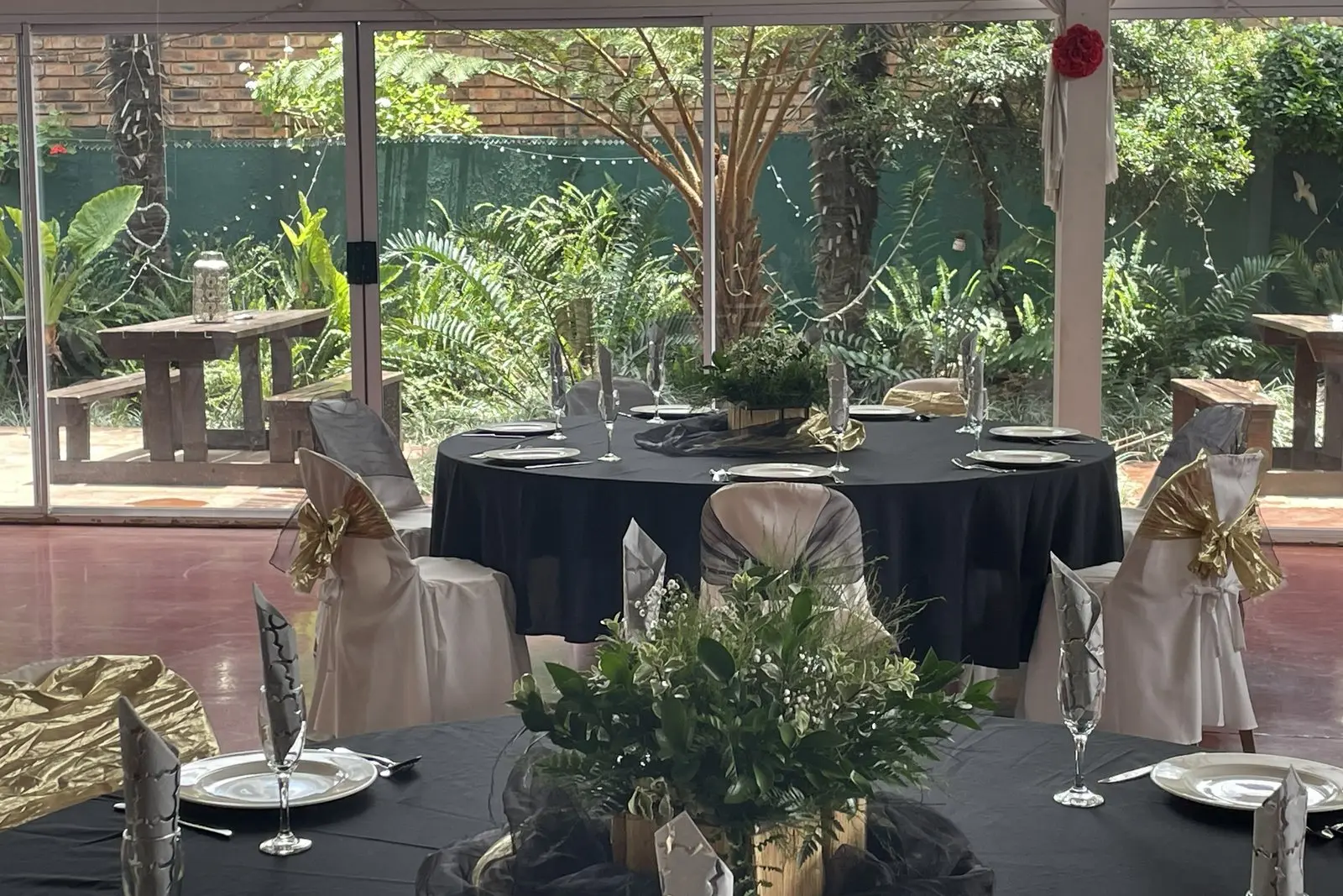 Black-draped tables with gold chairs set for an evening function