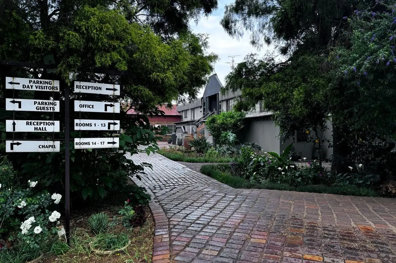 A brick pathway through the garden past directional signposts