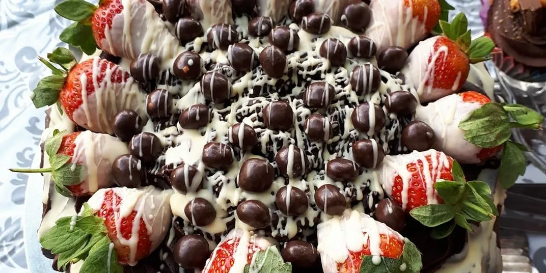 Chocolate-dipped strawberries arranged on a dessert table