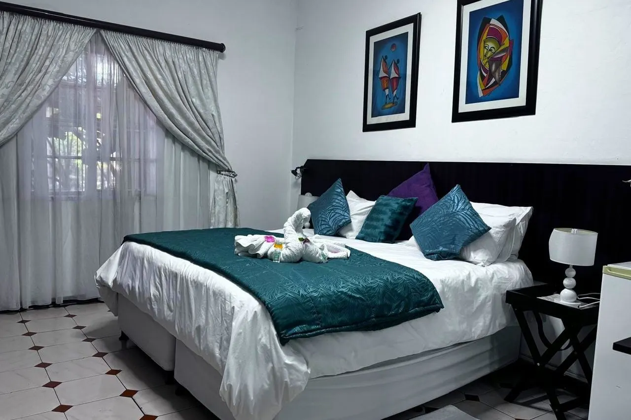 A room made up with teal and purple linen and natural light