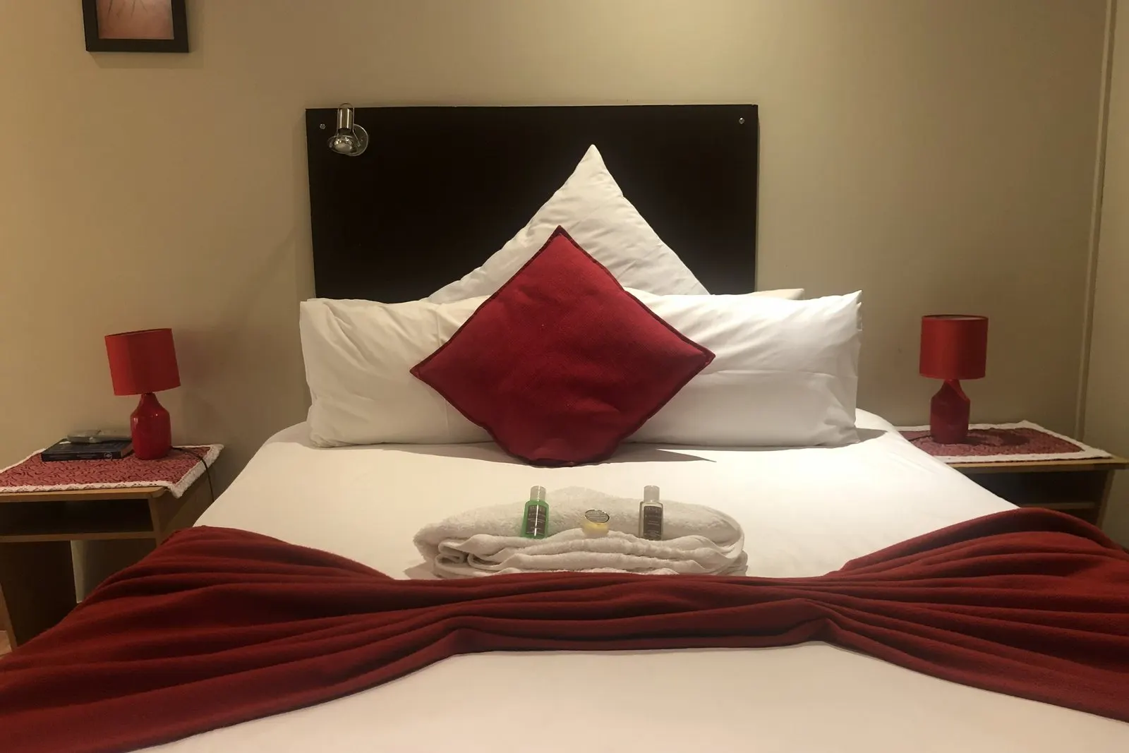 A double room dressed in deep red and white linen