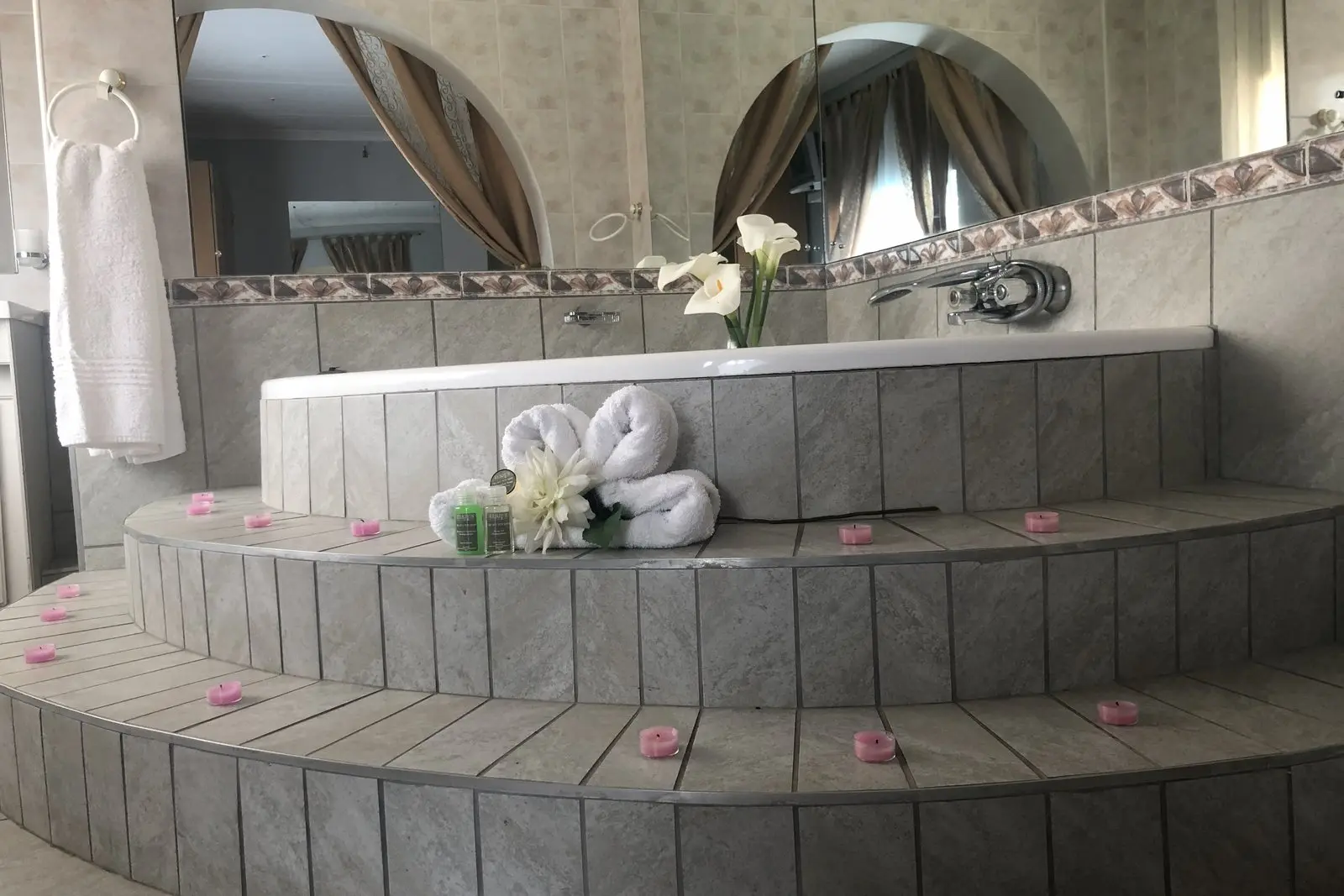 The corner spa bath in the Honeymoon Suite, with towel swans on the steps